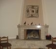 Τζάκι γωνιακό τραπέζιο με πυρότουβλο & επένδυση σκαπιτσαριστό μάρμαρο.
